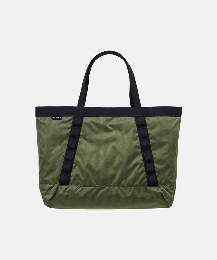 Olive Gramicci Trail Tote bag with black straps on a light tone background