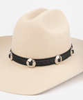 Beige cowboy hat with a black concho band featuring gold buttons on a white background #color_black
