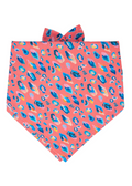 A bold tie-on dog bandana with a coral pink base and painterly leopard spots in  — the ultimate statement accessory.