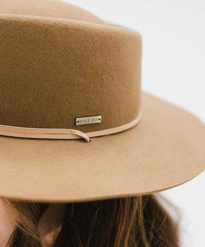 Close up image of a brown hat with a hat band against a white background #color_brown