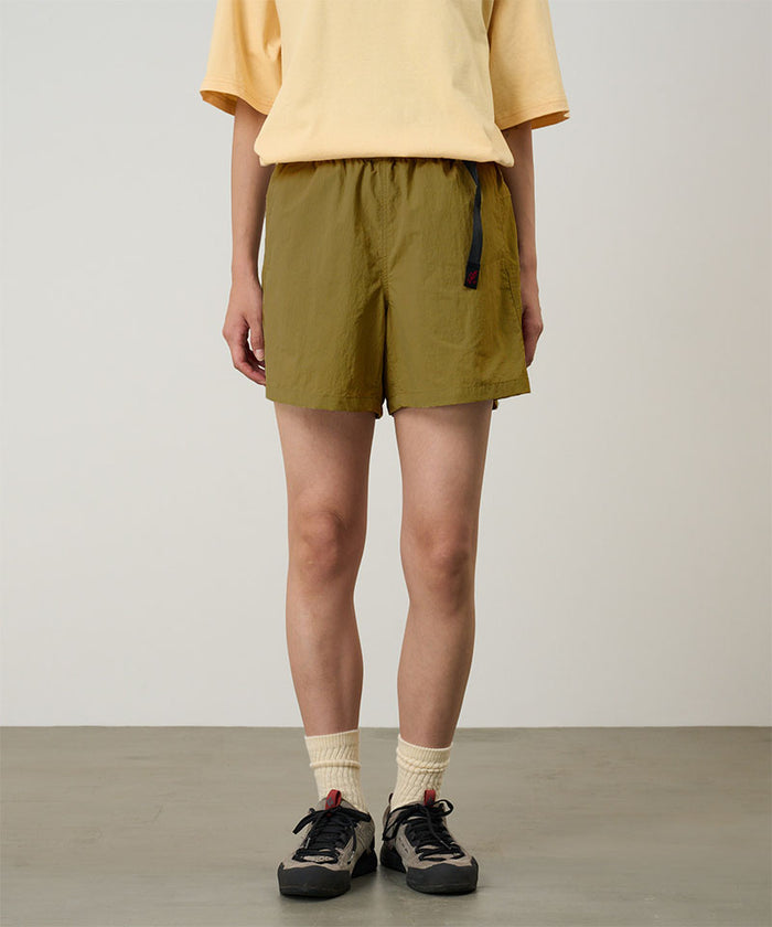 Model wearing artichoke Gramicci Women's Nylon Active Short and a yellow shirt on a light-tone background.