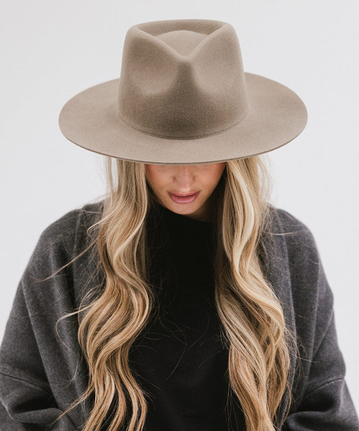 Woman wearing a sage fedora hat and a black top with a dark grey jacket against a white background #color_sage