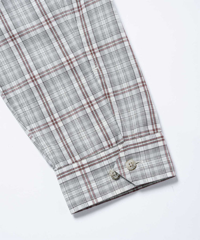Close-up of the cuff and sleeve on a natural shadow plaid Gramicci Zip-Up Garage Jacket on a light-tone background.