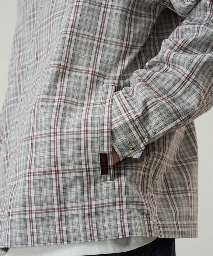 Model wearing a Gramicci natural shadow plaid Zip-Up Garage Jacket against a light-tone background.