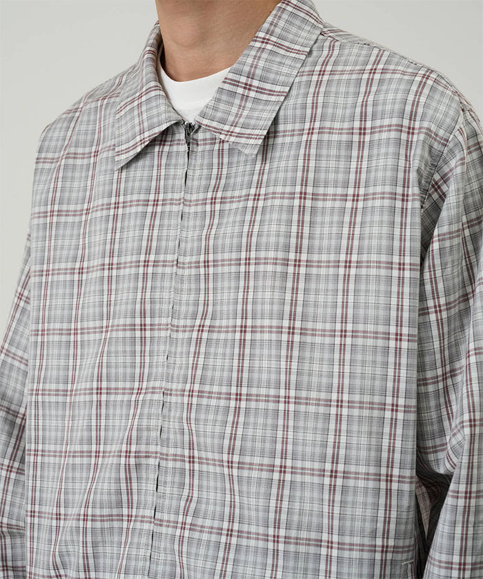 Model wearing a Gramicci natural shadow plaid Zip-Up Garage Jacket against a light-tone background.